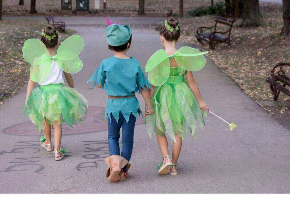Junge als Peter Pan, an seiner Seite zwei Mädchen als Elfen verkleidet
