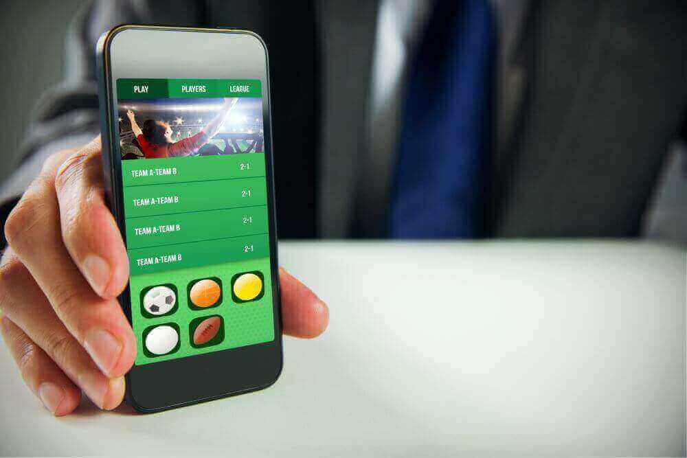 Mann benutzt Smartphone für Sportwetten