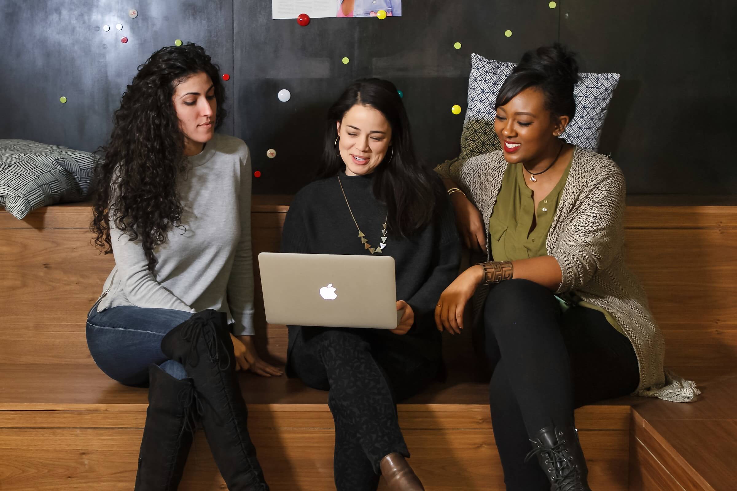 Drei Frauen vor einem Macbook