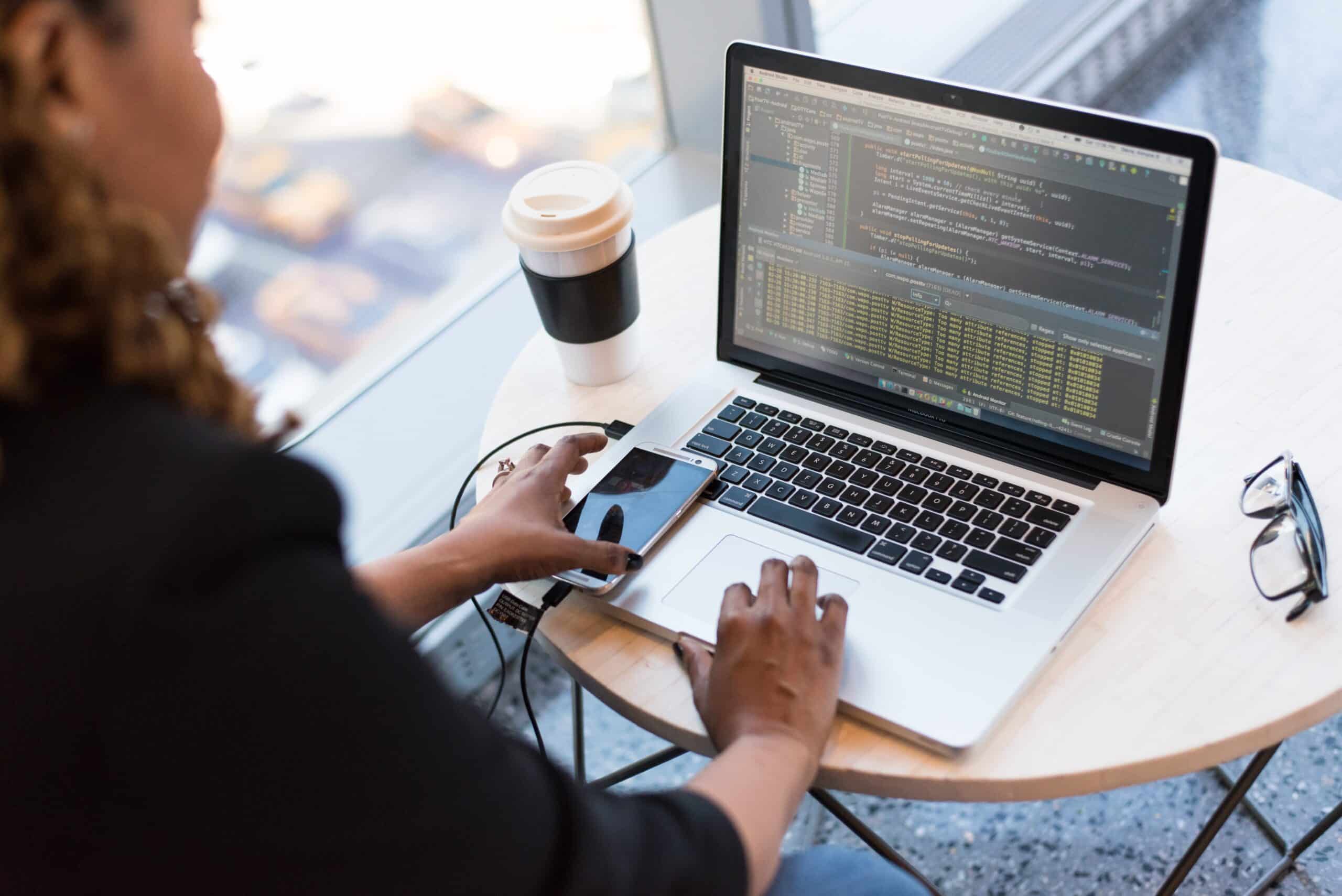 Eine Frau programmiert an einem MacBook